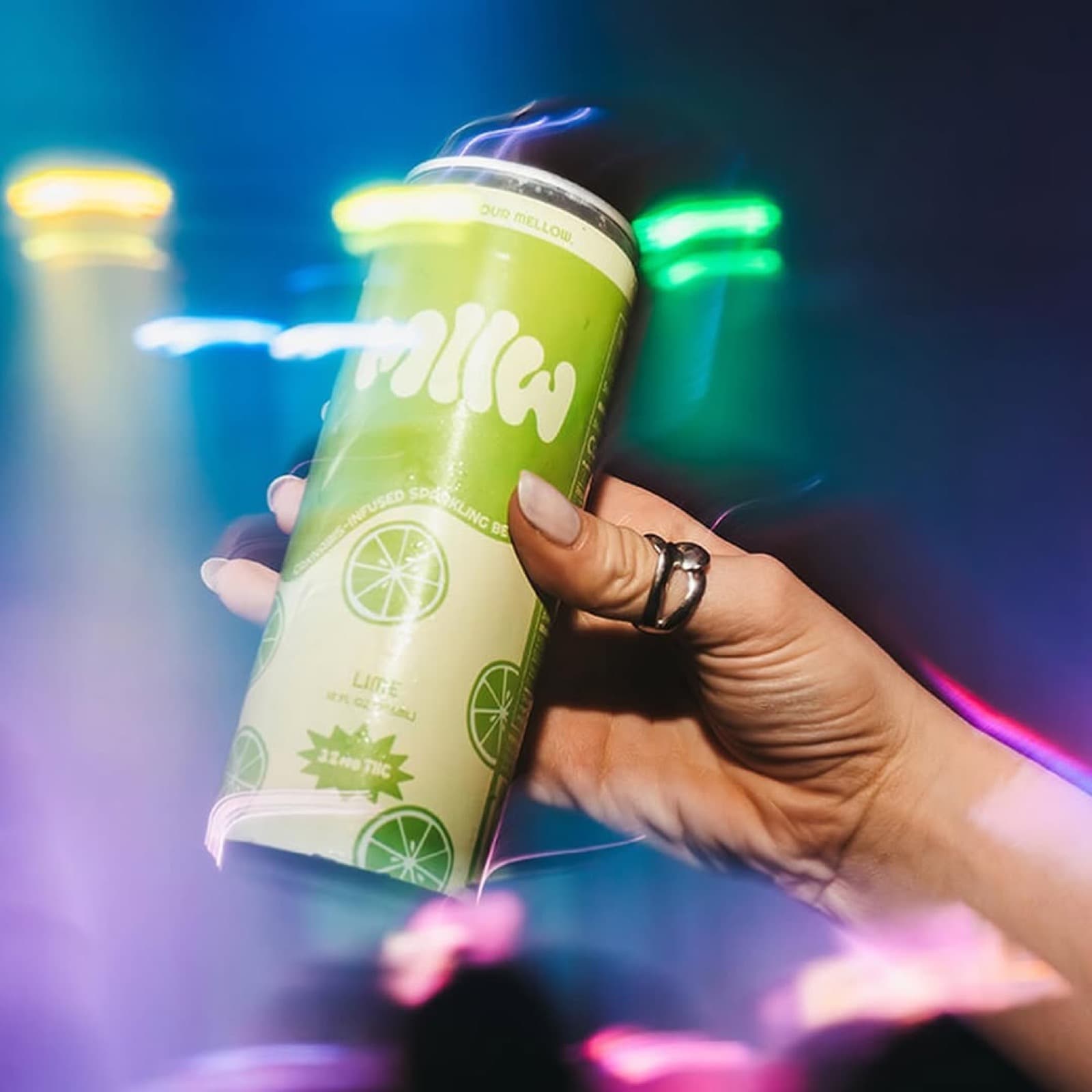 Lime MLLW can held aloft at concert under stage lights