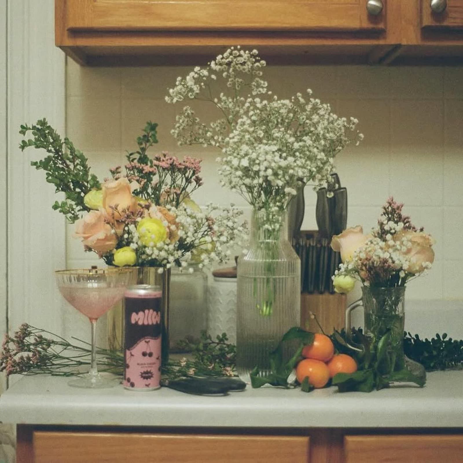 MLLW Black Cherry can on kitchen counter with florals and coupe glass